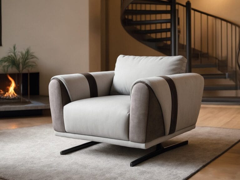 Modern gray armchair with black accents on a beige rug in a living room, with a spiral staircase and a lit fireplace in the background.
